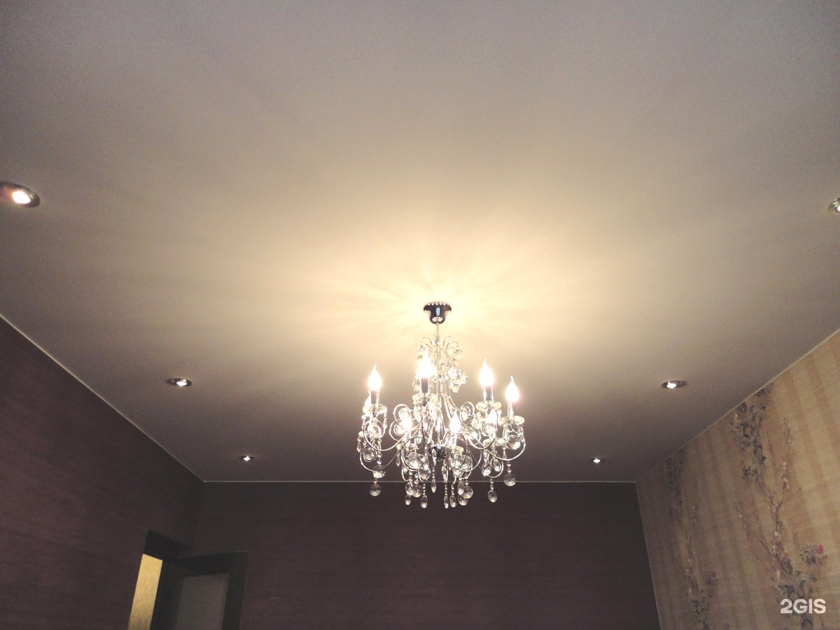Однокровневый потолок с точечными светильниками и люстр